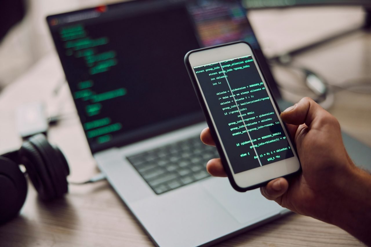 coding-laptop-and-phone-in-hand-with-man-programmer-and-software-update-information-technology-a.jpg